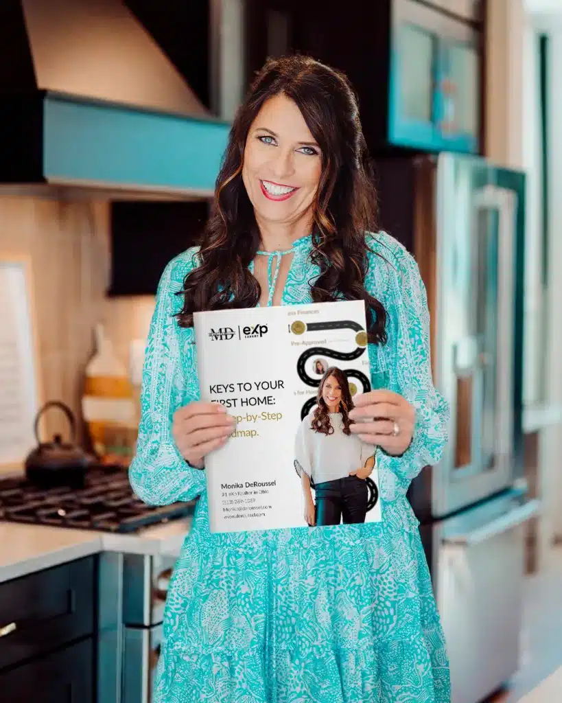 Monika DeRoussel holding a first-time home buyer guide for Cincinnati